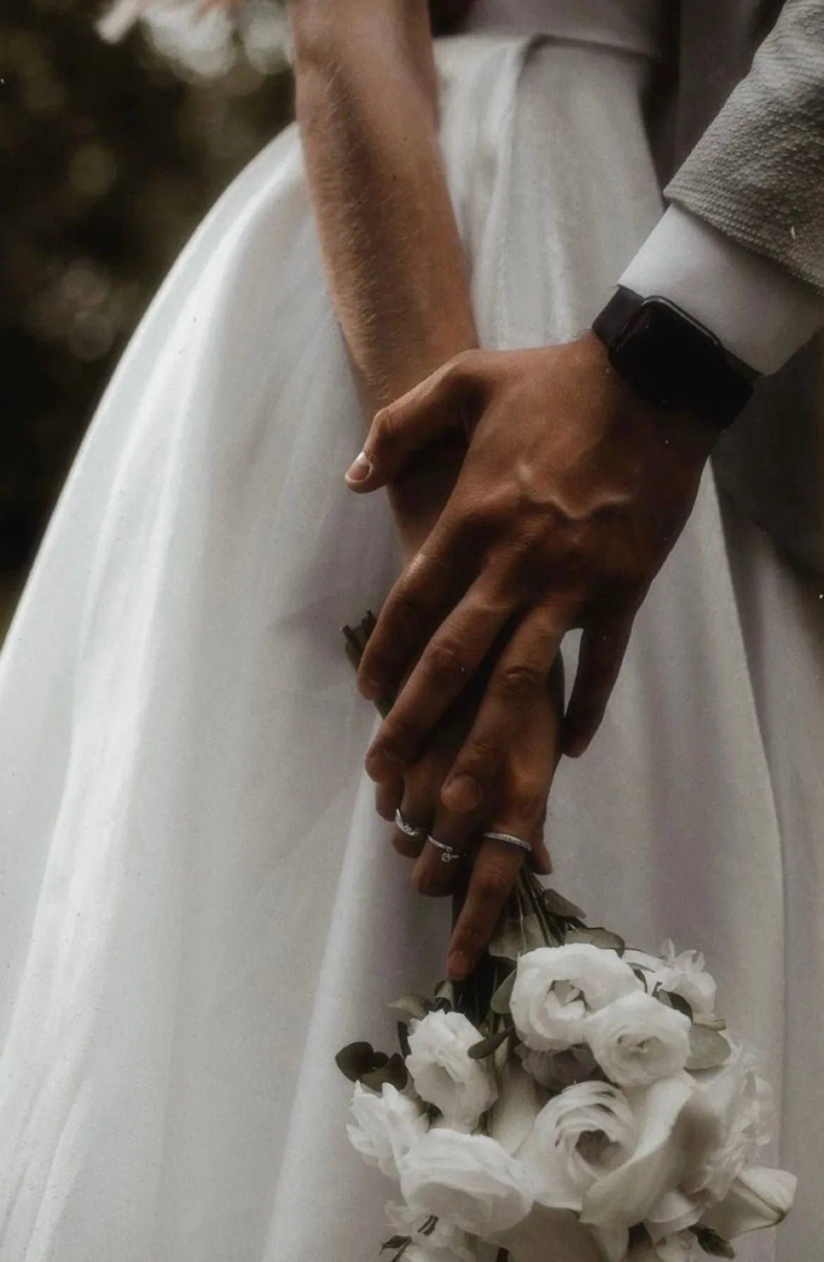 Manos de una pareja sobre el vestido de novia